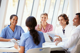 A group of doctors is having a discussion at a boardroom table