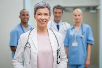A senior doctor stands with a group of residents