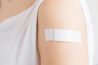 A woman with an adhesive bandage on her arm