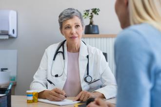 A doctor speaks with a young female patient