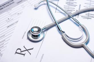 A written prescription with a stethoscope on top