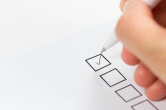 A hand is shown checking off a box on a survey
