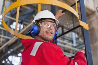 A worker is wearing a hard hat and hearing protection