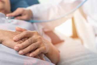 A doctor attends to a patient at home in bed