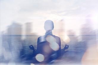 A person sitting in a meditation pose with a city skyline overlay