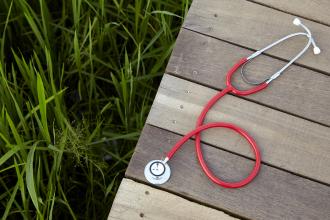A stethoscope on a wooden walkway in a field
