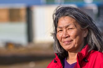 An Inuit woman stands outside in a northern community on Baffin Island