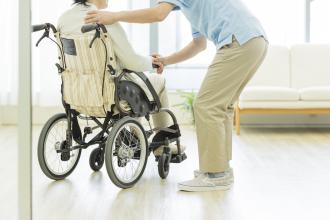 An aide assists a senior using a wheelchair