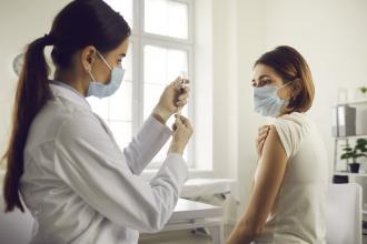A doctor prepares to administer a vaccine