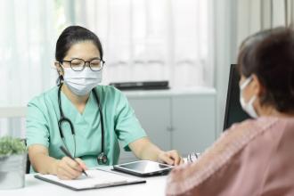 A doctor completes a checklist with a patient