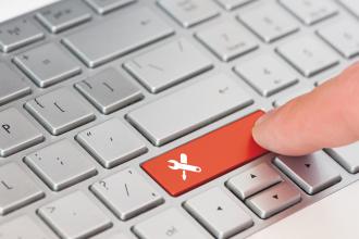 A finger is shown pressing a key on a computer keyboard with a toolkit icon