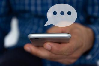 A graphic of a speech bubble is coming from a mobile phone