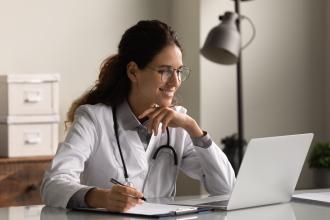 A doctor works on a computer