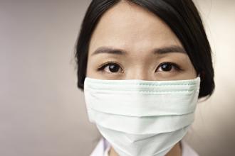An Asian health care worker wearing a mask