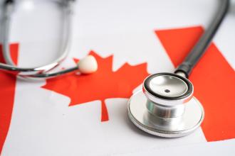 A stethoscope sits on top of a Canada flag