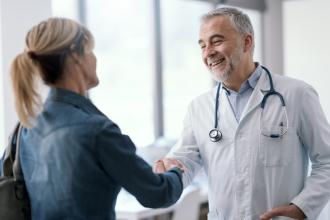 A senior doctor greets their patient