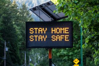 A road sign with the words "Stay home stay safe".