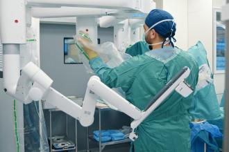 A surgeon sets up robotic surgery equipment.