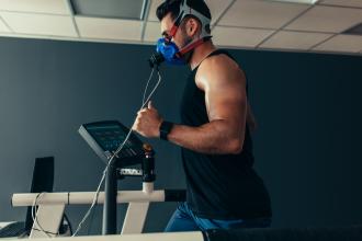 Athlete running on treadmill with elevation mask on 