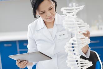 Biologist studying a DNA strand model