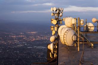 Transmitters and aerials on telecommunication tower during sunset