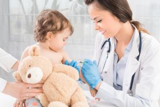 Little girl getting vaccination by female doctor