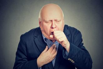 Old man coughing into his fist - copd