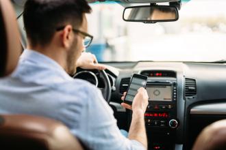 Man using his phone while at the wheel of a car