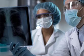 Doctors studying x-ray of lungs in lab, analyzing and discussing diagnosis