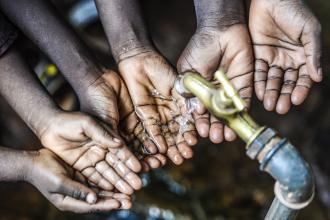 Symbol for fresh water for Africa, sets of hands under fresh pouring water