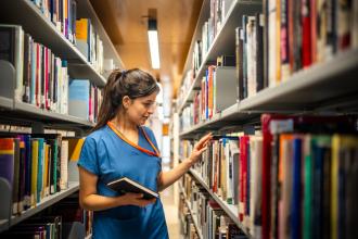 Medical staff looking through library stacks