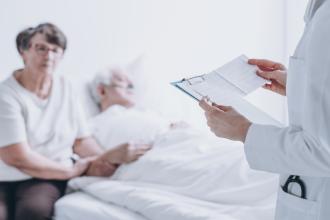 Doctor speaking with patient and patient's partner in hospital room