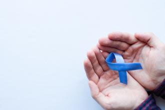 Man's two hands holding a blue ribbon