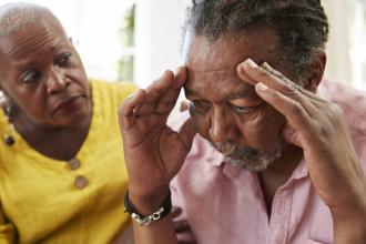 Senior Woman Comforting Man With Depression At Home