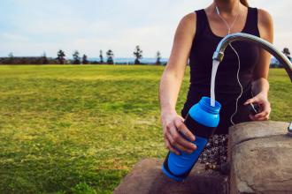 Female runner filling her bottle at a tap