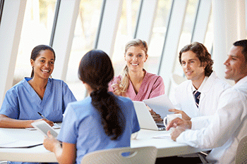 A group of doctors is having a discussion at a boardroom table