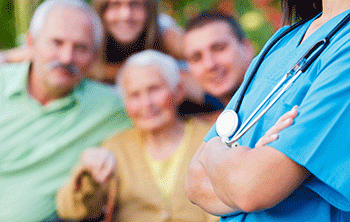 A doctor stands with an elderly couple and their adult children