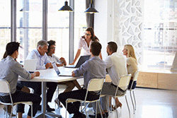 A group of professionals sits around a boardroom table having a meeting