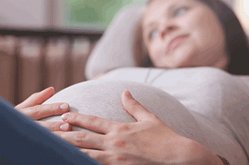 A pregnant woman is lying down on an examination table