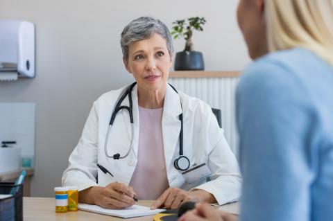 A doctor speaks with a young female patient