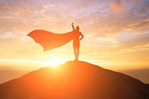 A silhouette of a woman with a superhero cape