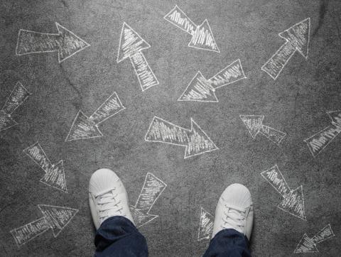 A pair of shoes on the floor, with arrows going in several different directions