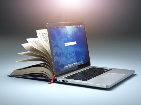 A laptop with an open book behind the screen, giving the idea of online learning