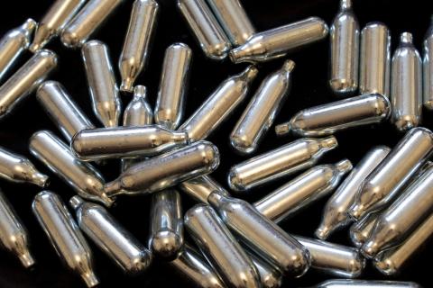 Nitrous oxide metal bulb canisters on a black background