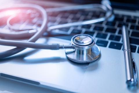 A stethoscope sits on top of a computer keyboard