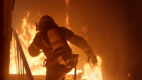 A firefighter rushes into a burning building