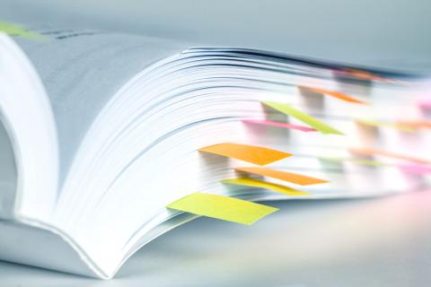 A book with colorful sticky notes marking various pages