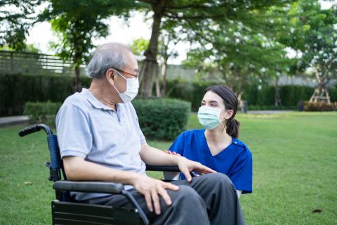 A care aide assists a senior using a wheelchair