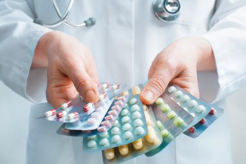 A pharmacist holds several packages of antibiotics
