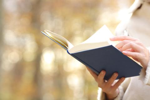 A person turns a page in a book